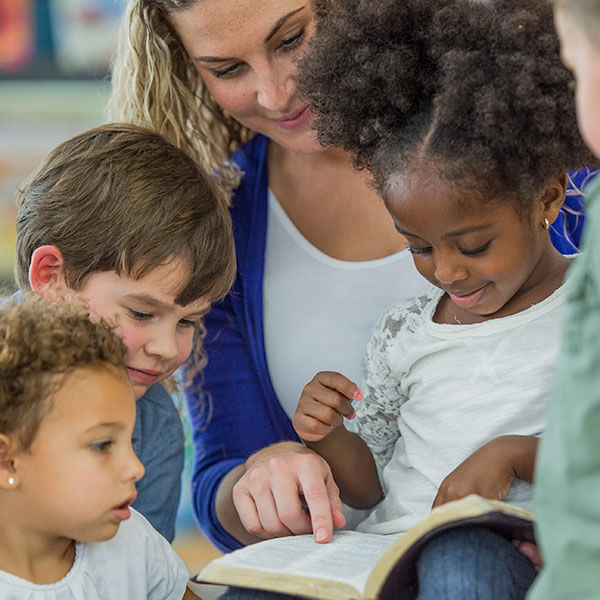 young children reading with teacher
